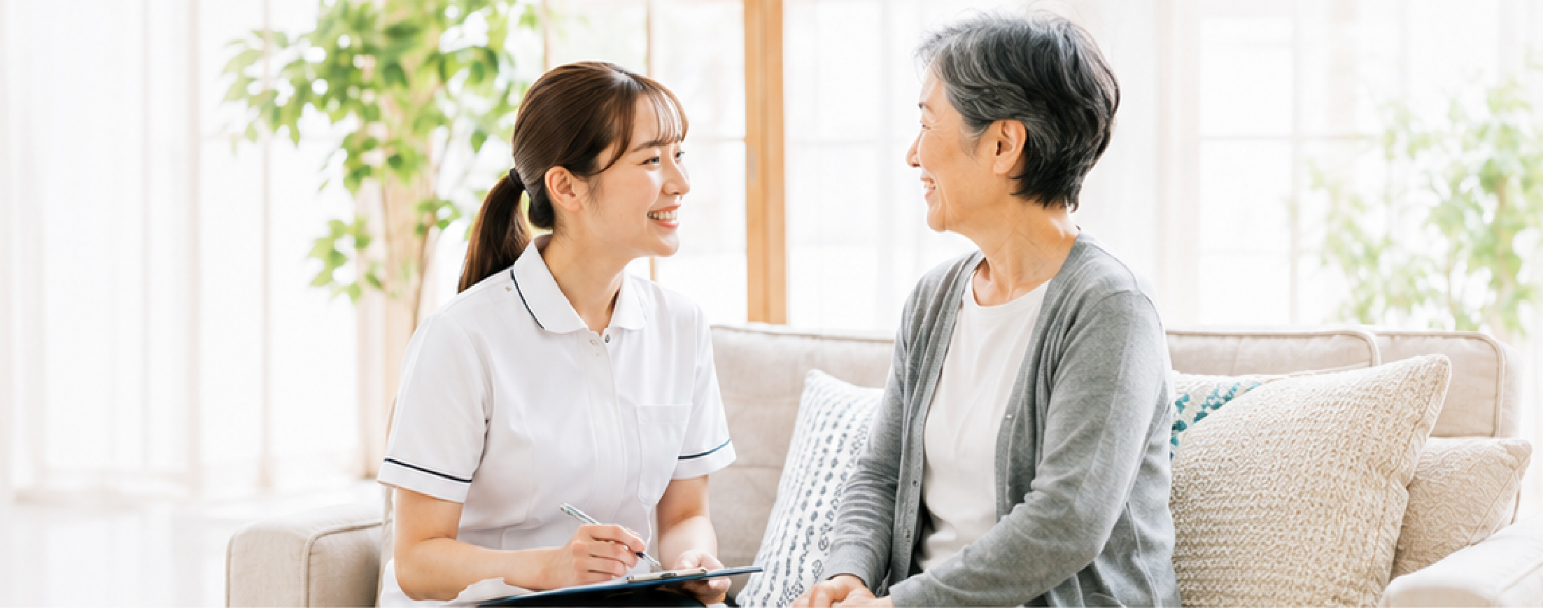 訪問看護スタッフが利用者さまと明るく会話している様子